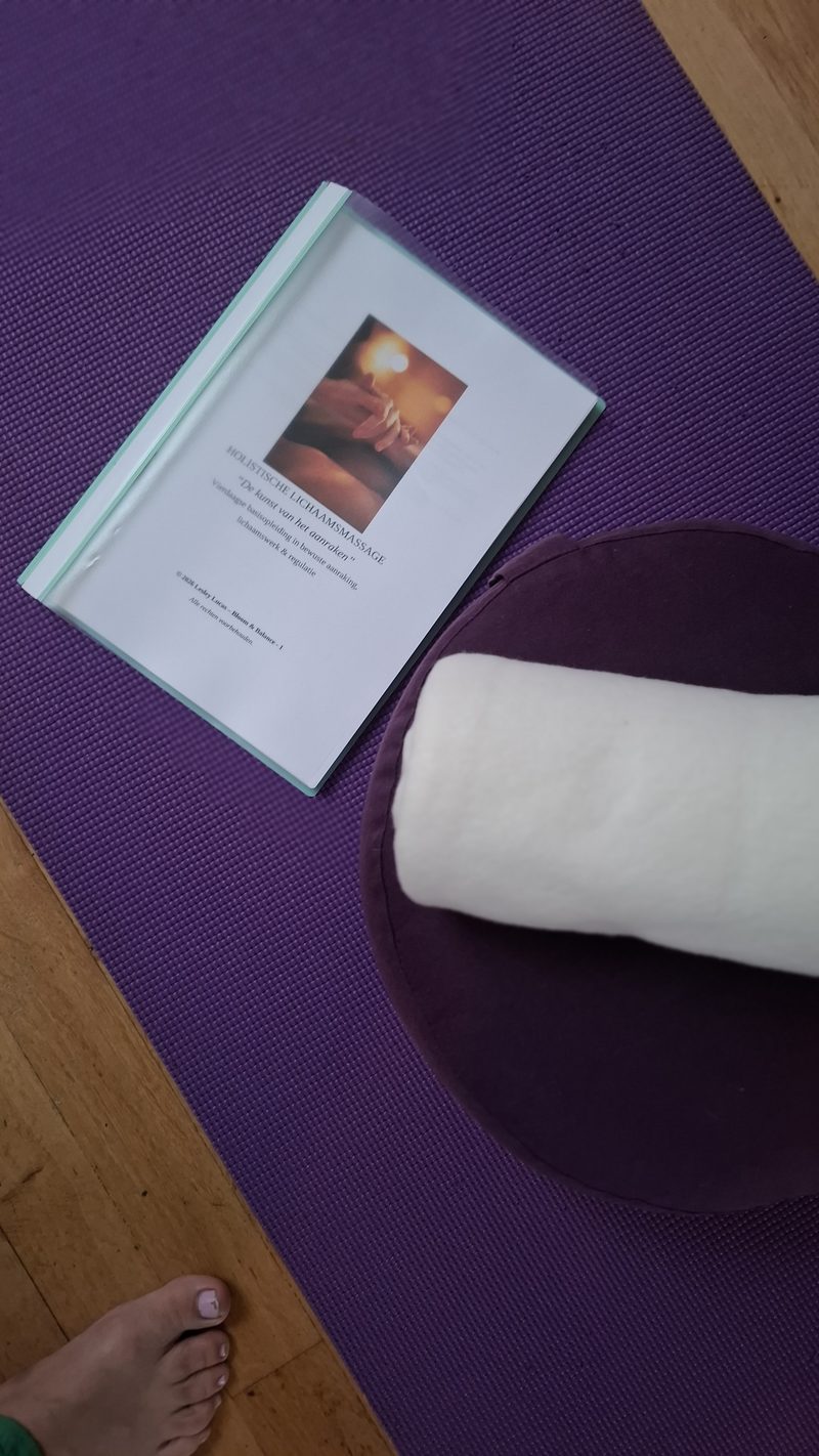De cursusmap ligt klaar op een paarse mat, naast een opgerolde handdoek
