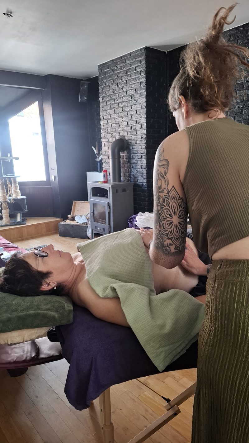 Een deelnemer oefent een massage aan de massagetafel